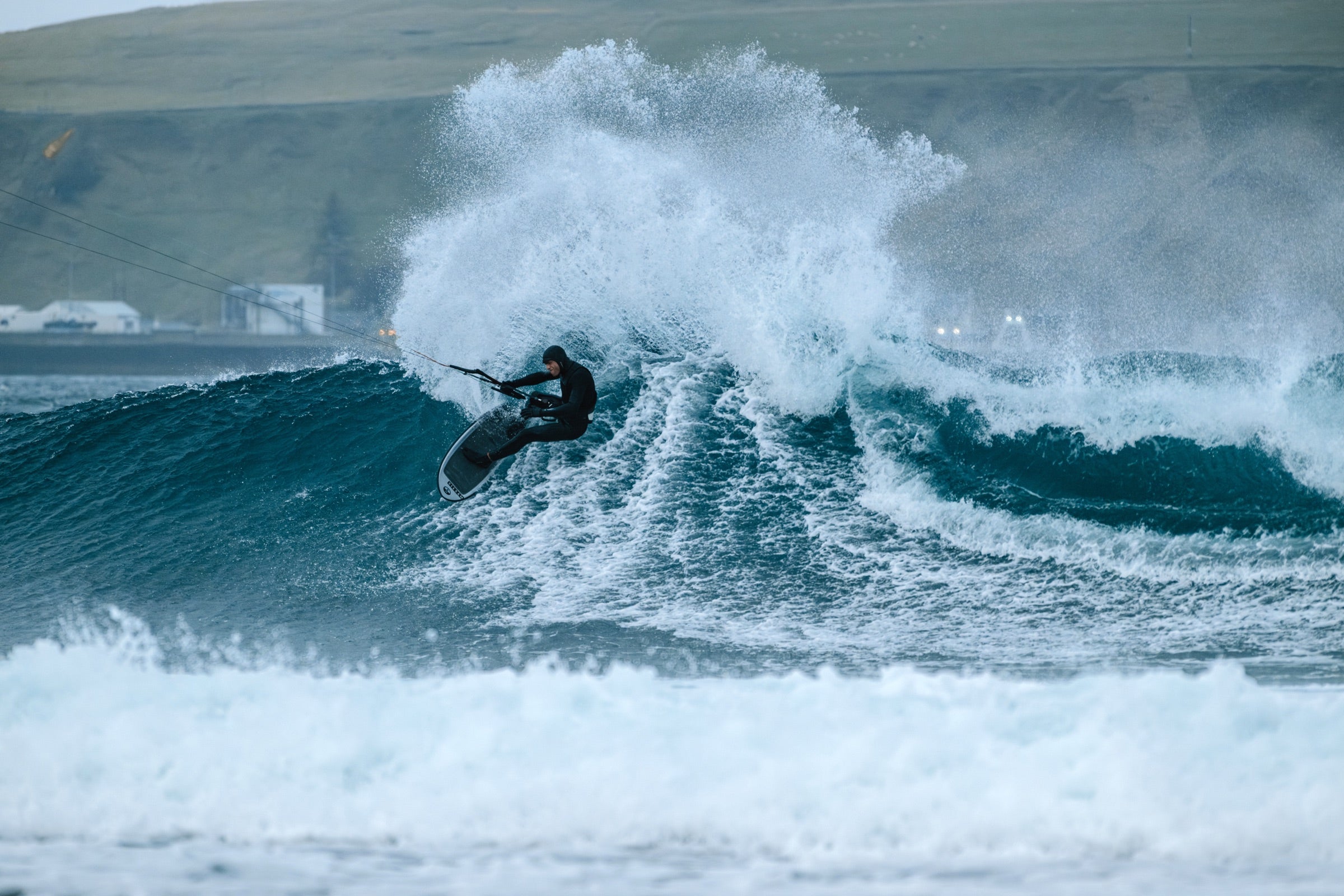 Kitesurfer carving a wave